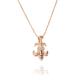 The picture shows a 14K yellow gold fleur-de-lis pendant with hand engravings.