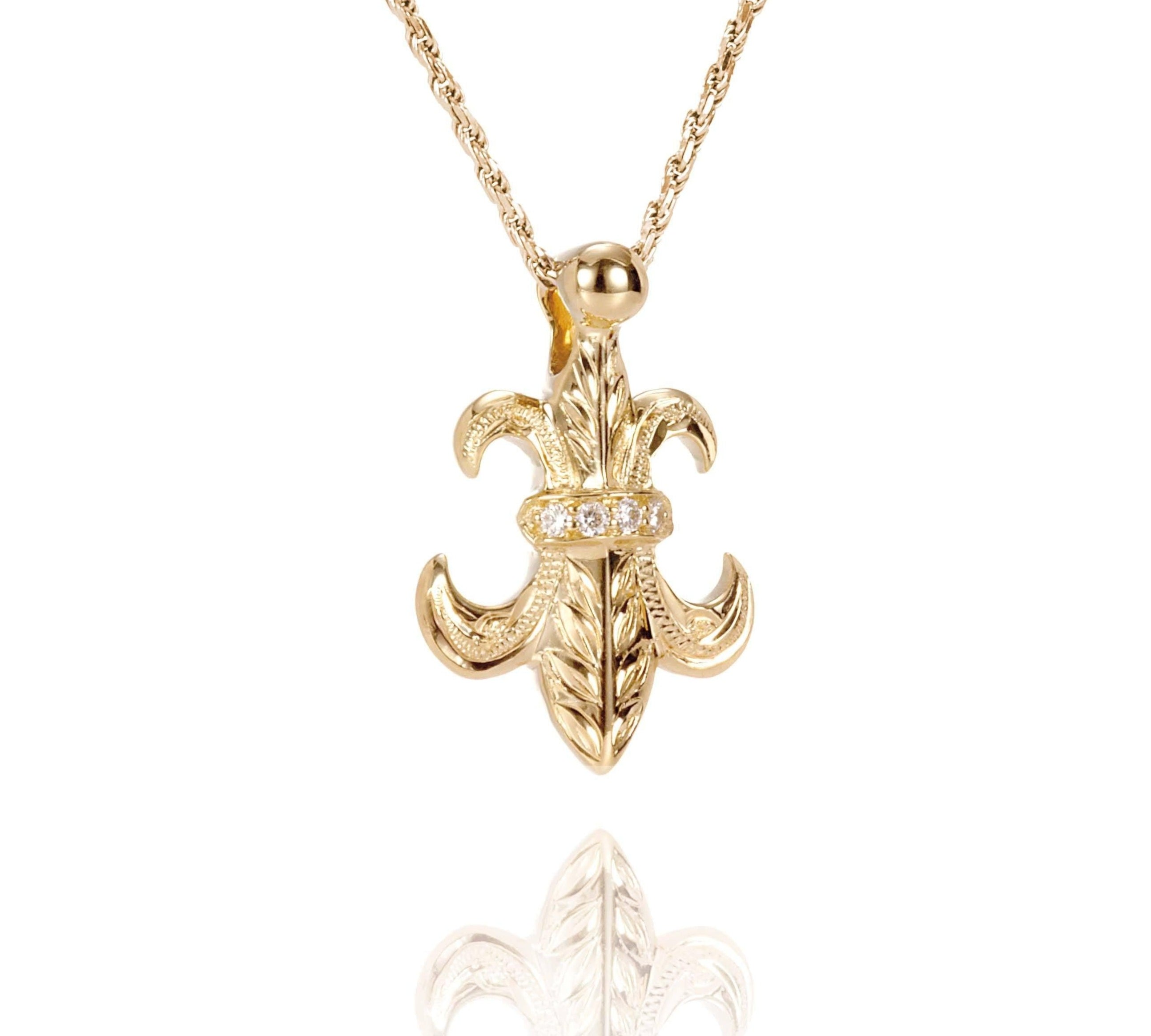 The picture shows a large 14K yellow gold fleur de lis pendant with hand engravings.