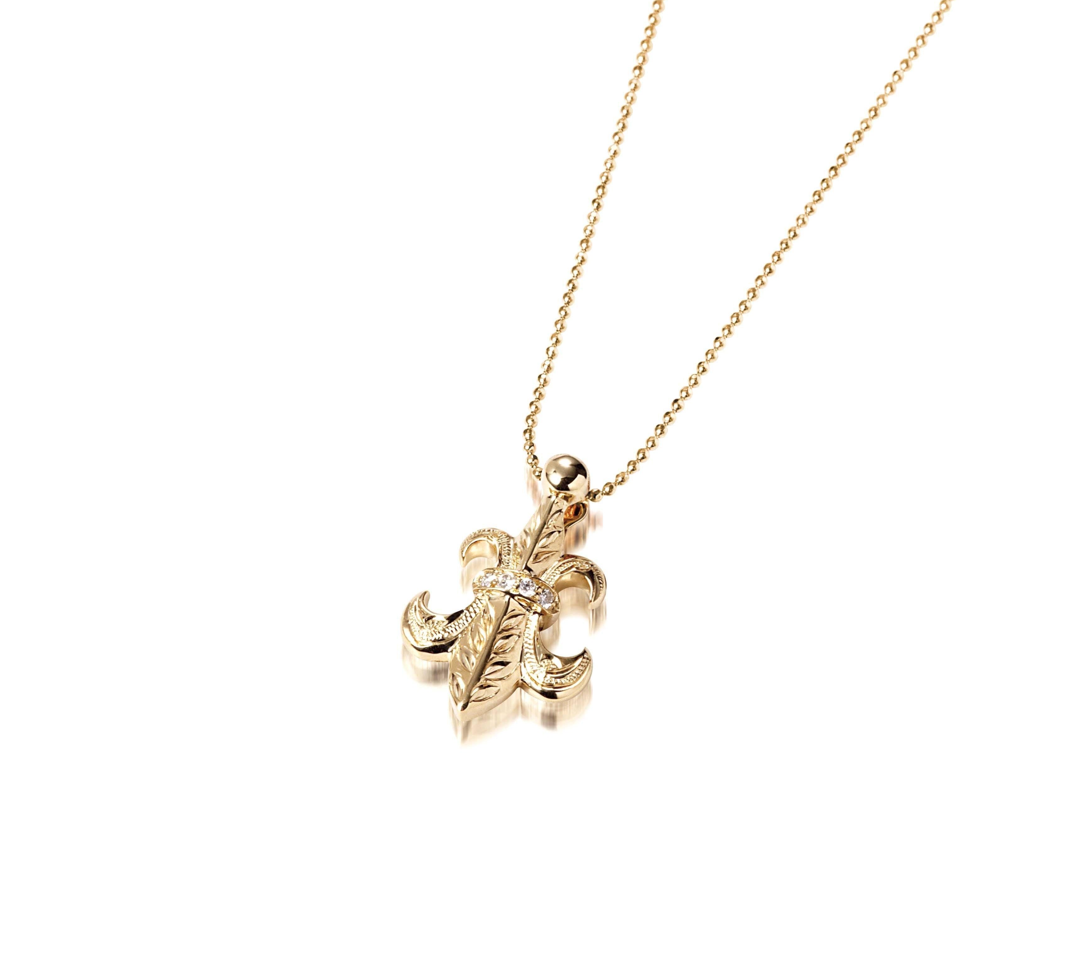 The picture shows a large 14K yellow gold fleur de lis pendant with hand engravings.
