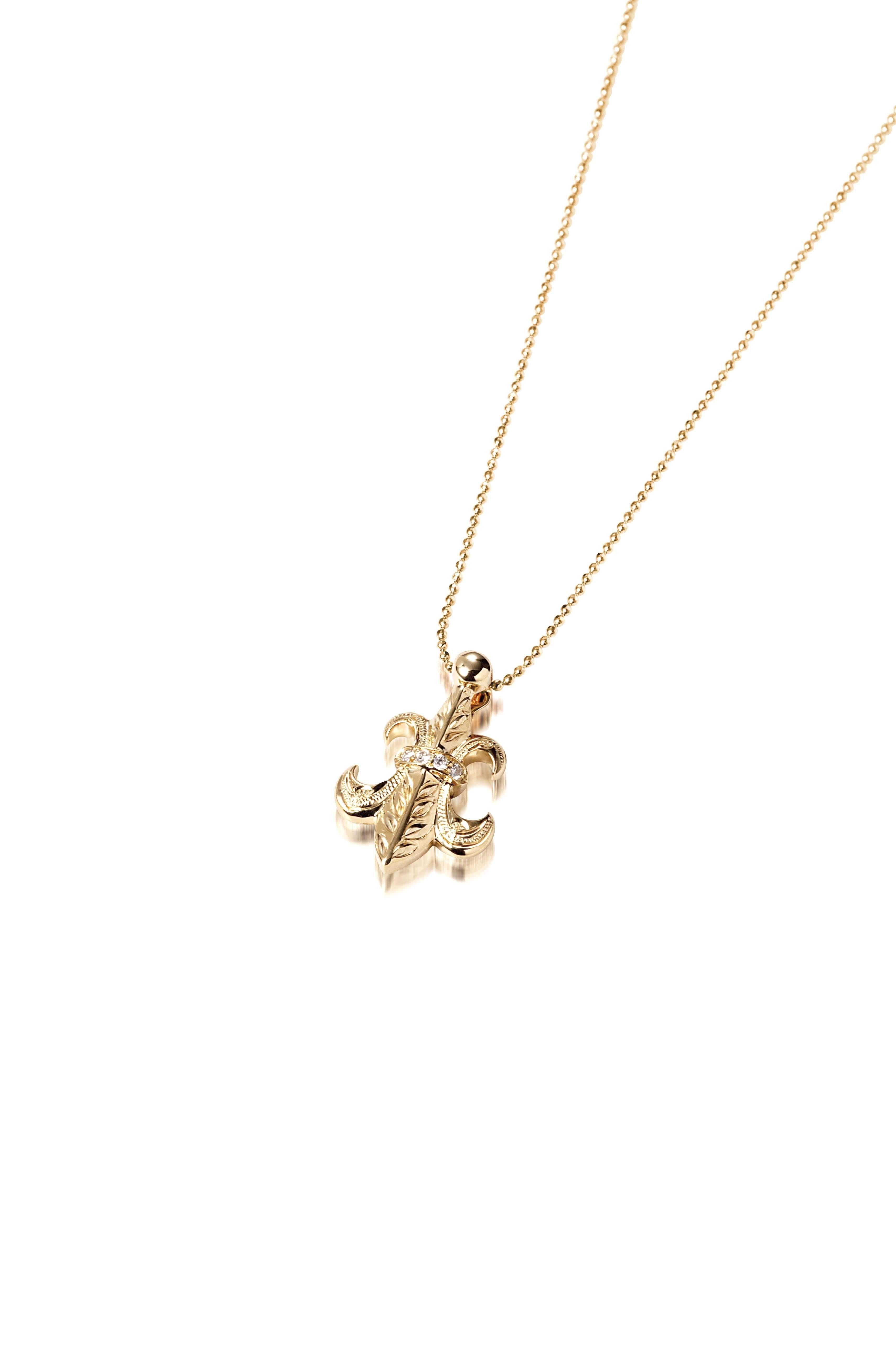 The picture shows a large 14K yellow gold fleur de lis pendant with hand engravings.