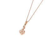 In this photo there is a 14k rose gold heart charm with plumeria engraving.