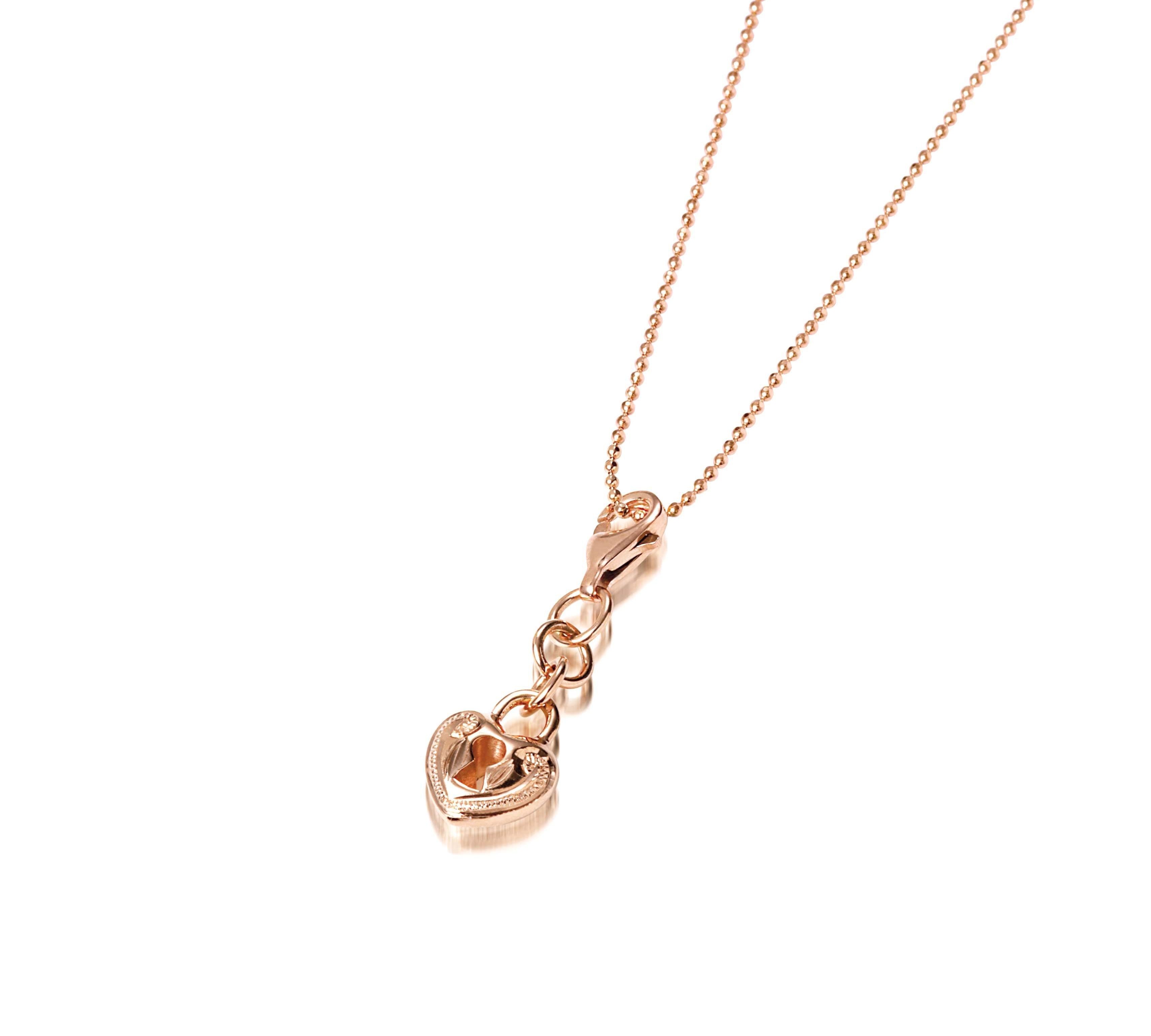 The picture shows a 14K rose gold heart Lock charm with hand-engraved detailing.