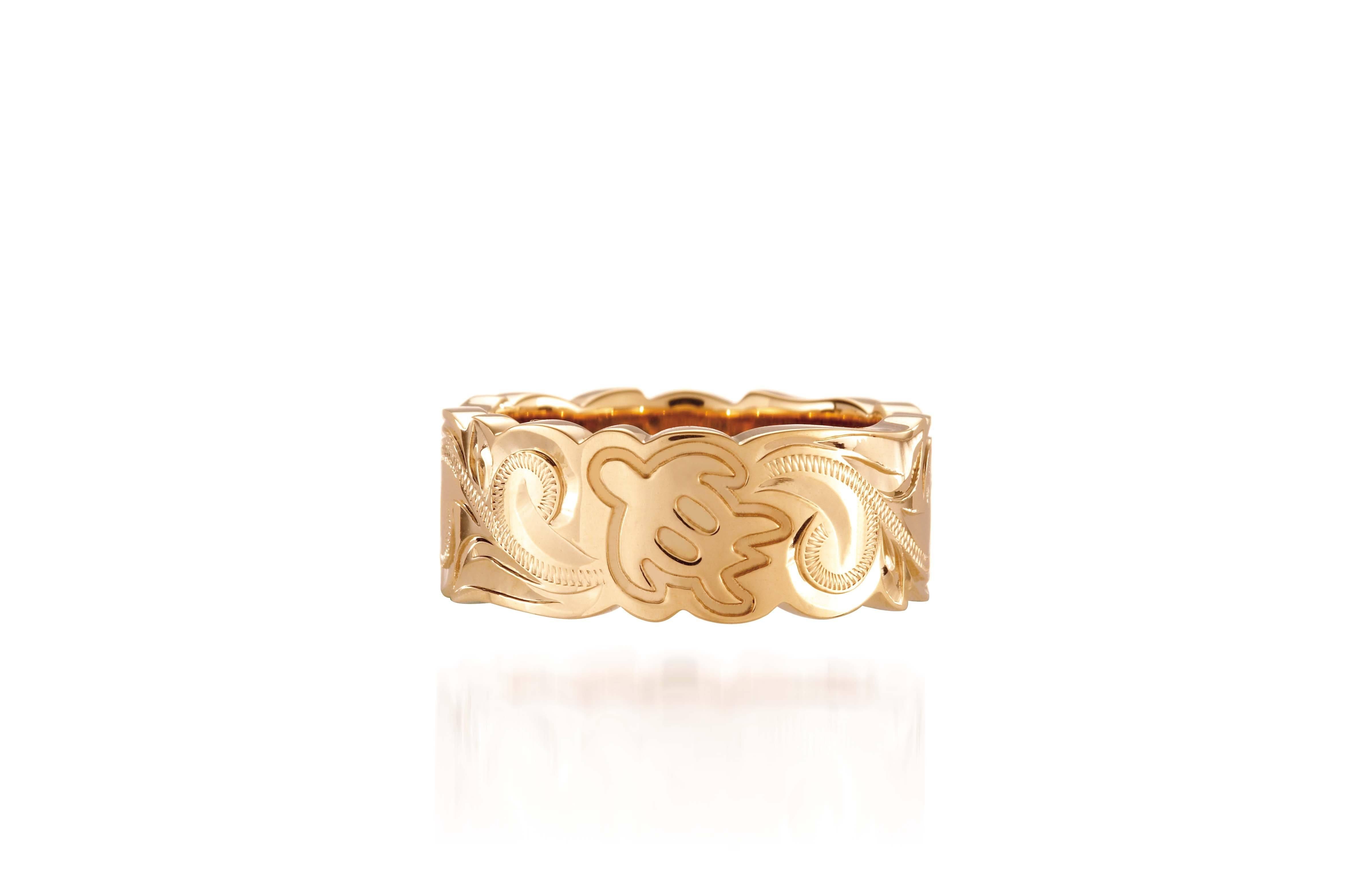 The picture shows a 14K yellow gold cut out 8 mm ring with hand engravings including sea turtles.