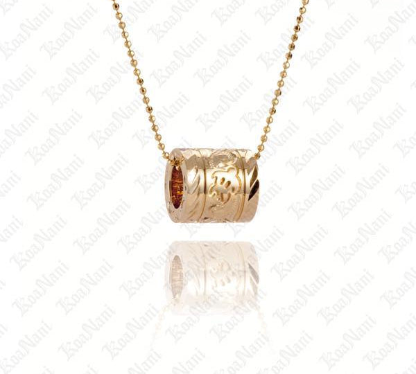 The picture shows a hand-engraved 14K yellow gold sea turtle barrel pendant.