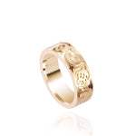 The photo shows a 6 mm 14K yellow gold ring with hand engravings including sea turtles.