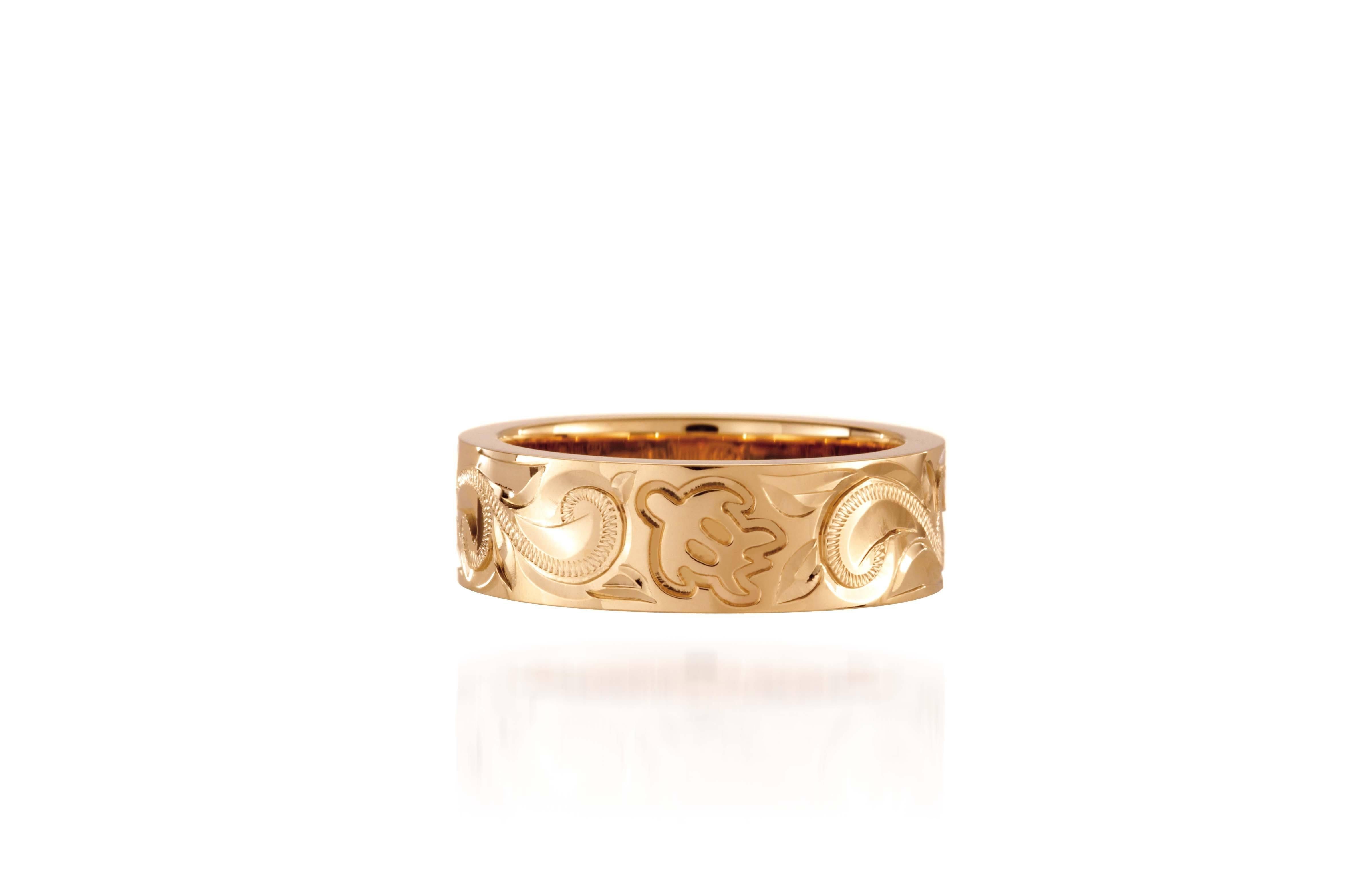 The photo shows a 6 mm 14K yellow gold ring with hand engravings including sea turtles.