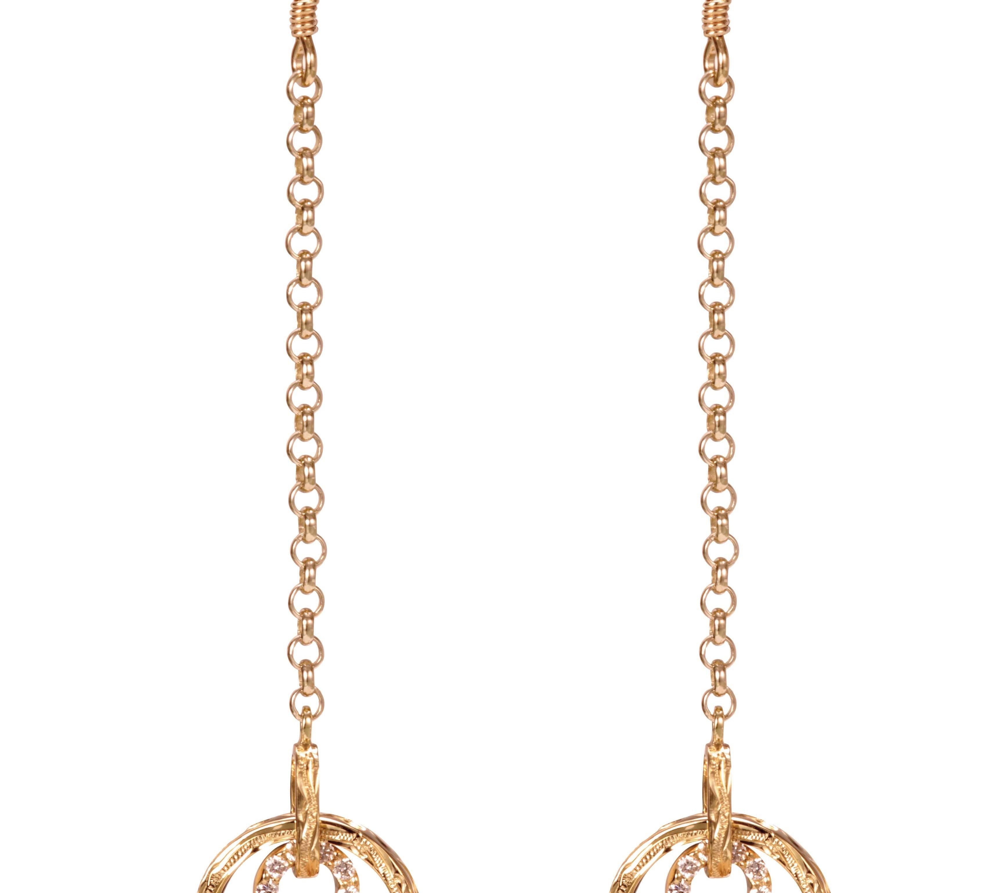 The picture shows a pair of 14K yellow gold infinity scroll hook earrings with diamonds.