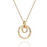 The picture shows a 14K yellow gold two circle infinity scroll pendant with hand engravings and diamonds.
