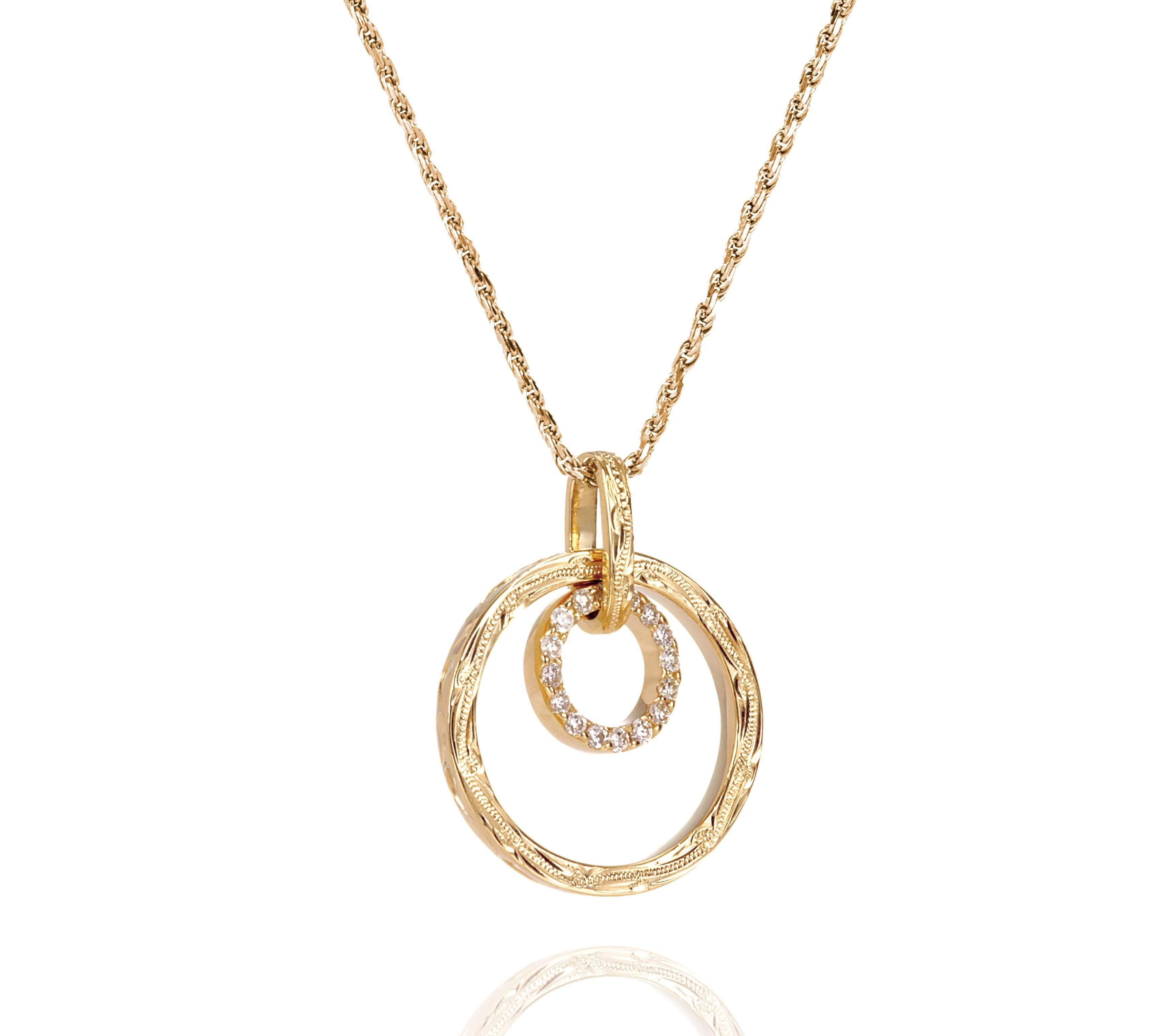 The picture shows a 14K yellow gold two circle infinity scroll pendant with hand engravings and diamonds.
