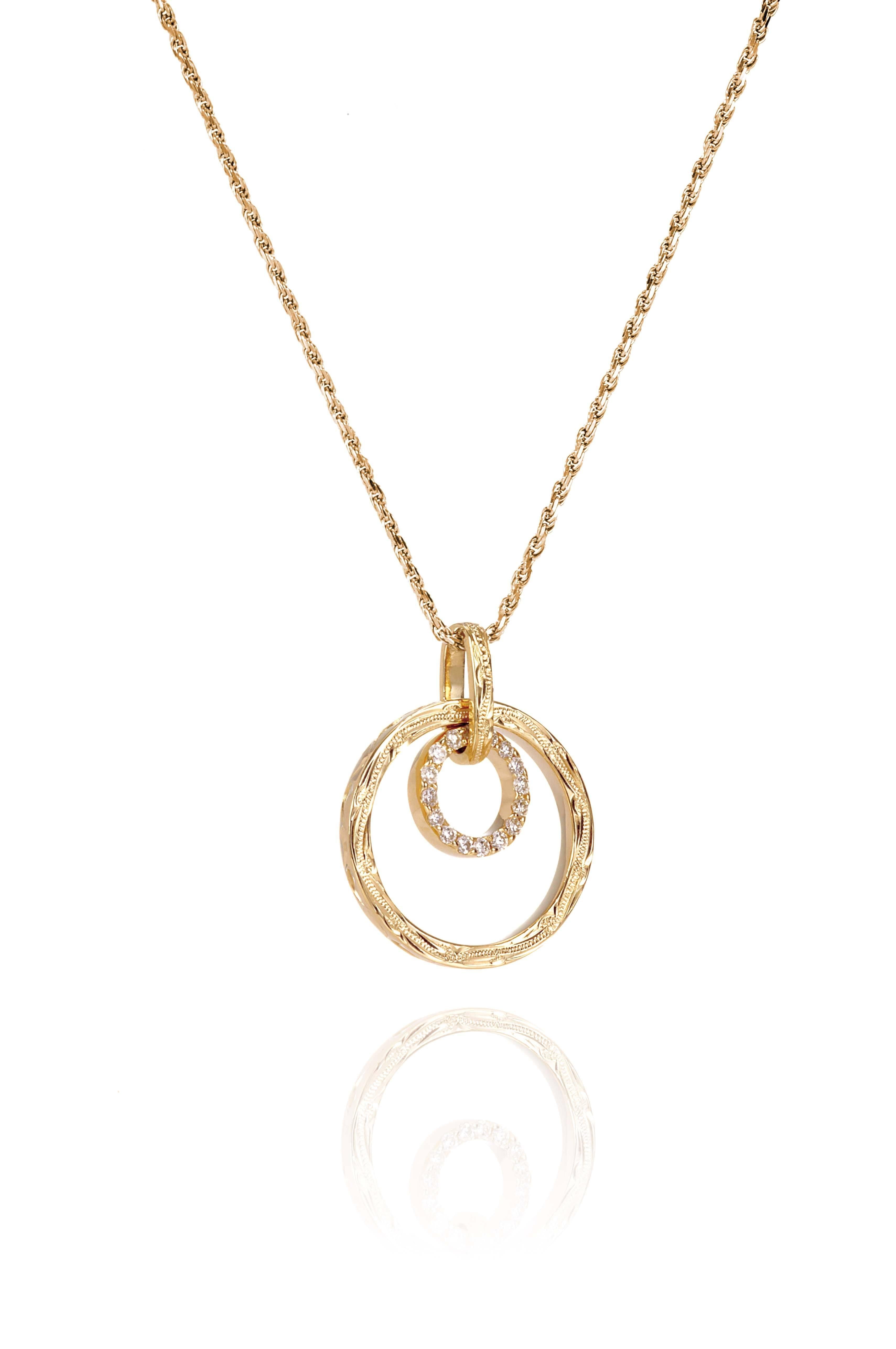 The picture shows a 14K yellow gold two circle infinity scroll pendant with hand engravings and diamonds.