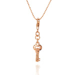 The picture shows a 14K yellow gold key charm with hand-engraved detailing.