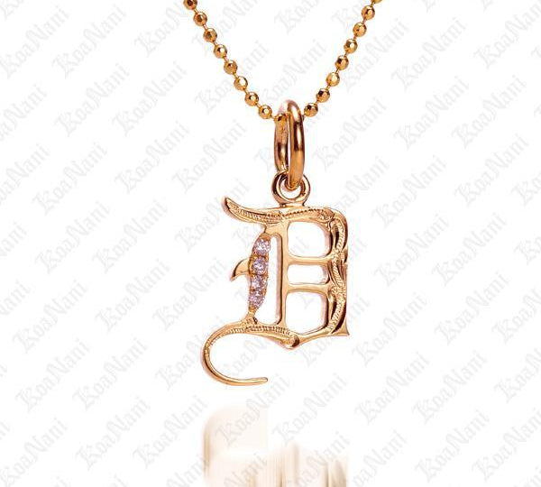 The picture shows a 14K yellow gold Koa Nani D initial pendant.