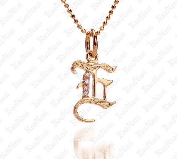 The picture shows a 14K yellow gold Koa Nani E initial pendant.