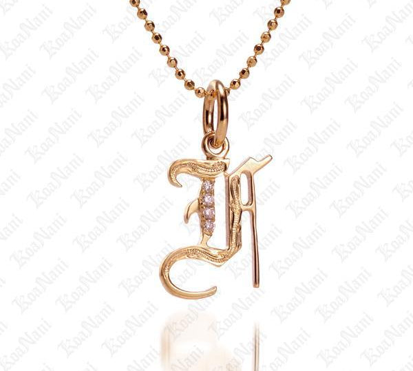 The picture shows a 14K yellow gold Koa Nani F initial pendant.