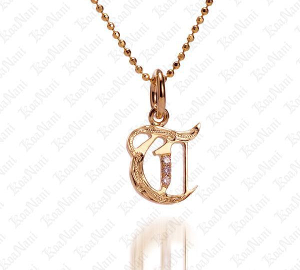 The picture shows a 14K yellow gold Koa Nani T initial pendant.