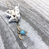 The picture shows a 14K yellow gold sea turtle pendant with a larimar gemstone.