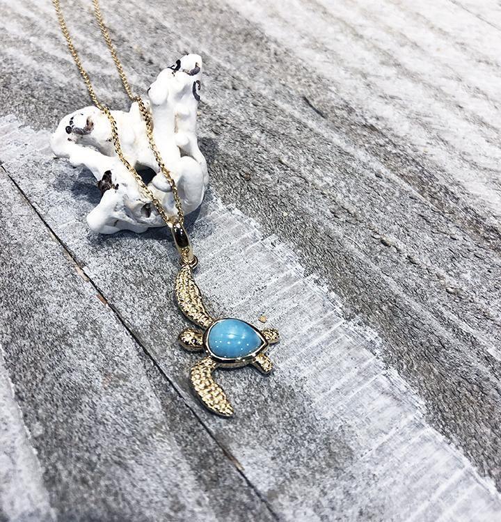 The picture shows a 14K yellow gold sea turtle pendant with a larimar gemstone.