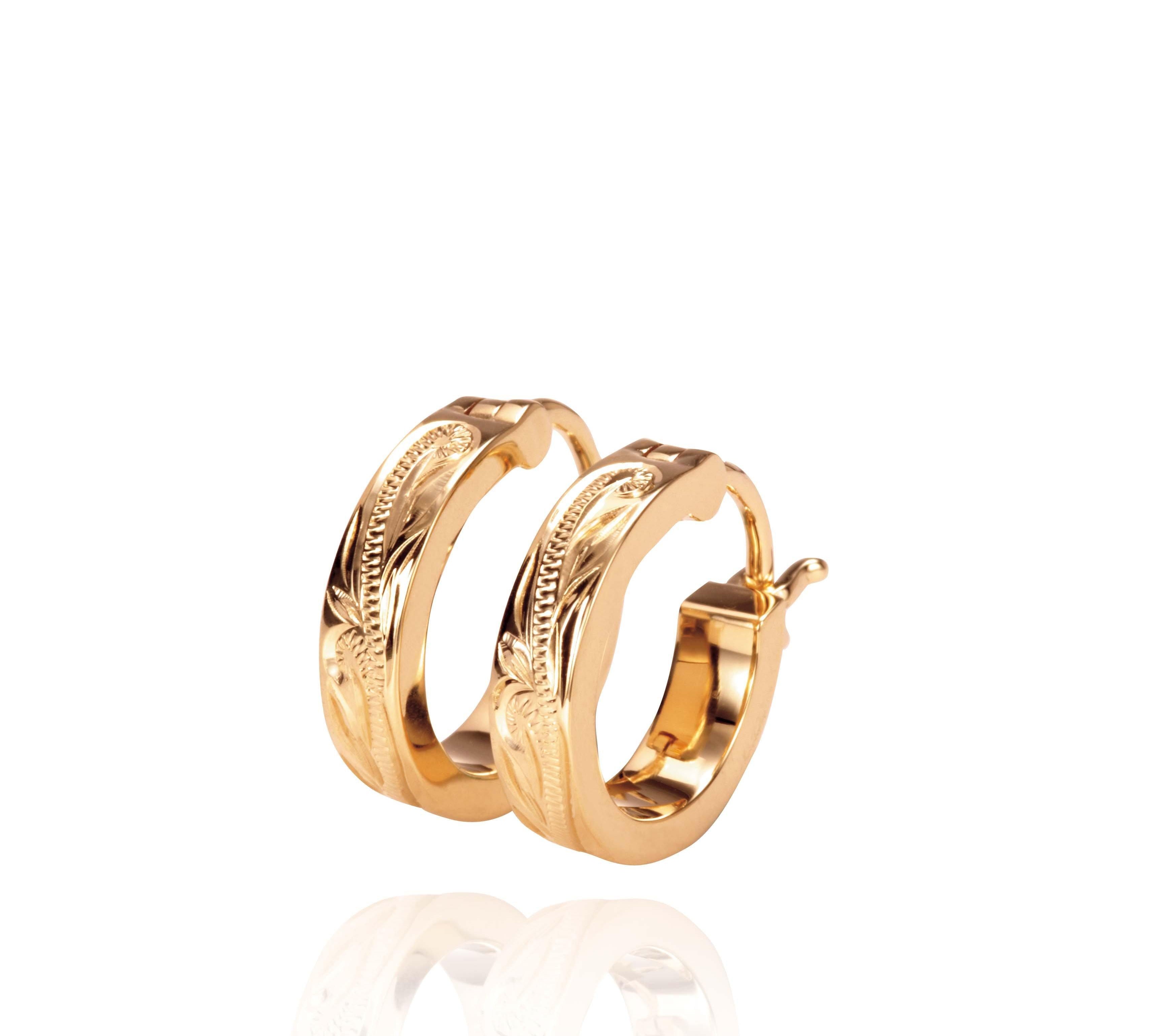 The picture shows a pair of 14K yellow gold mini hoop earrings with scroll engraving.