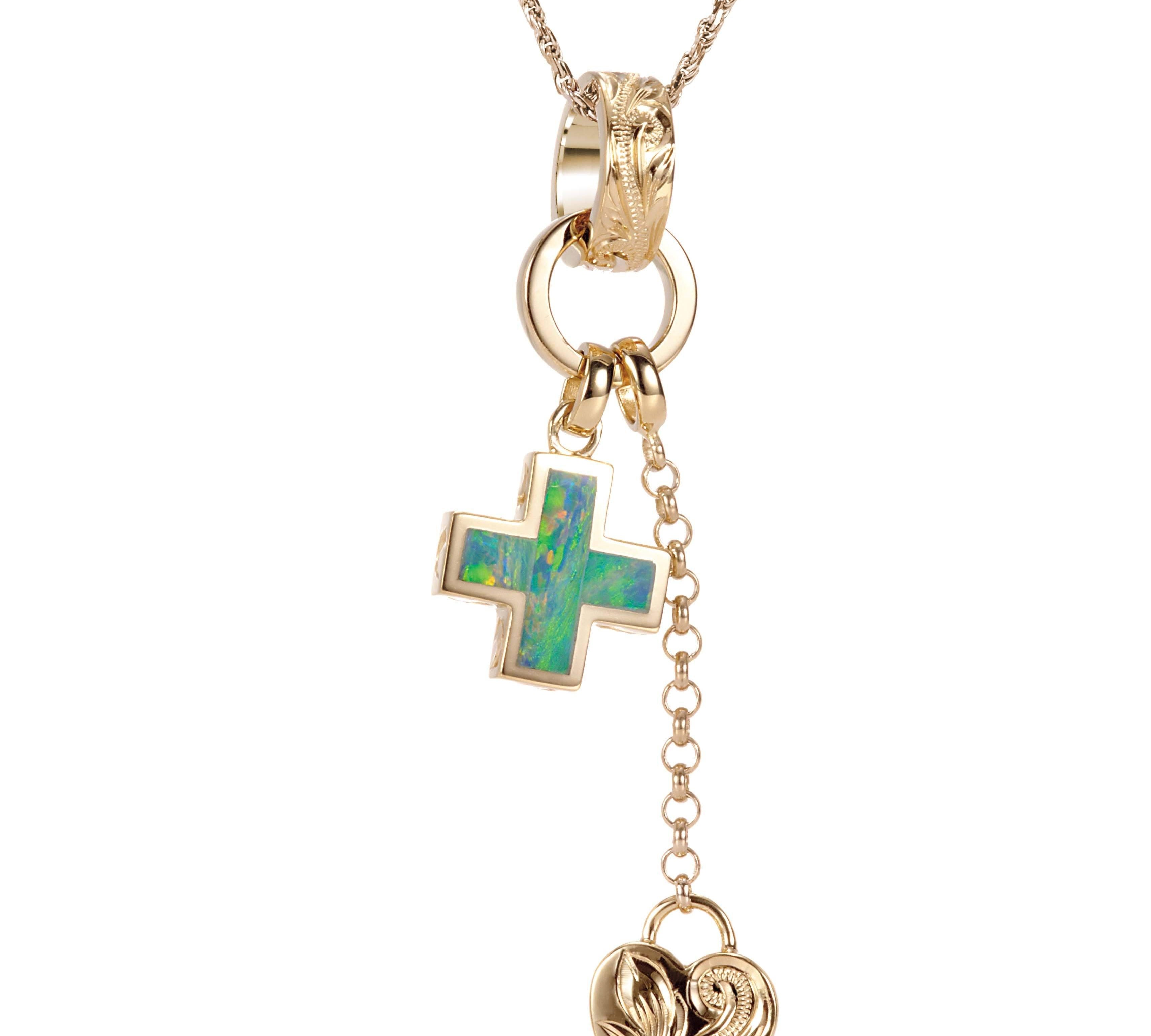 The picture shows a 14K yellow gold opal cross and heart charm pendant with hand engravings.