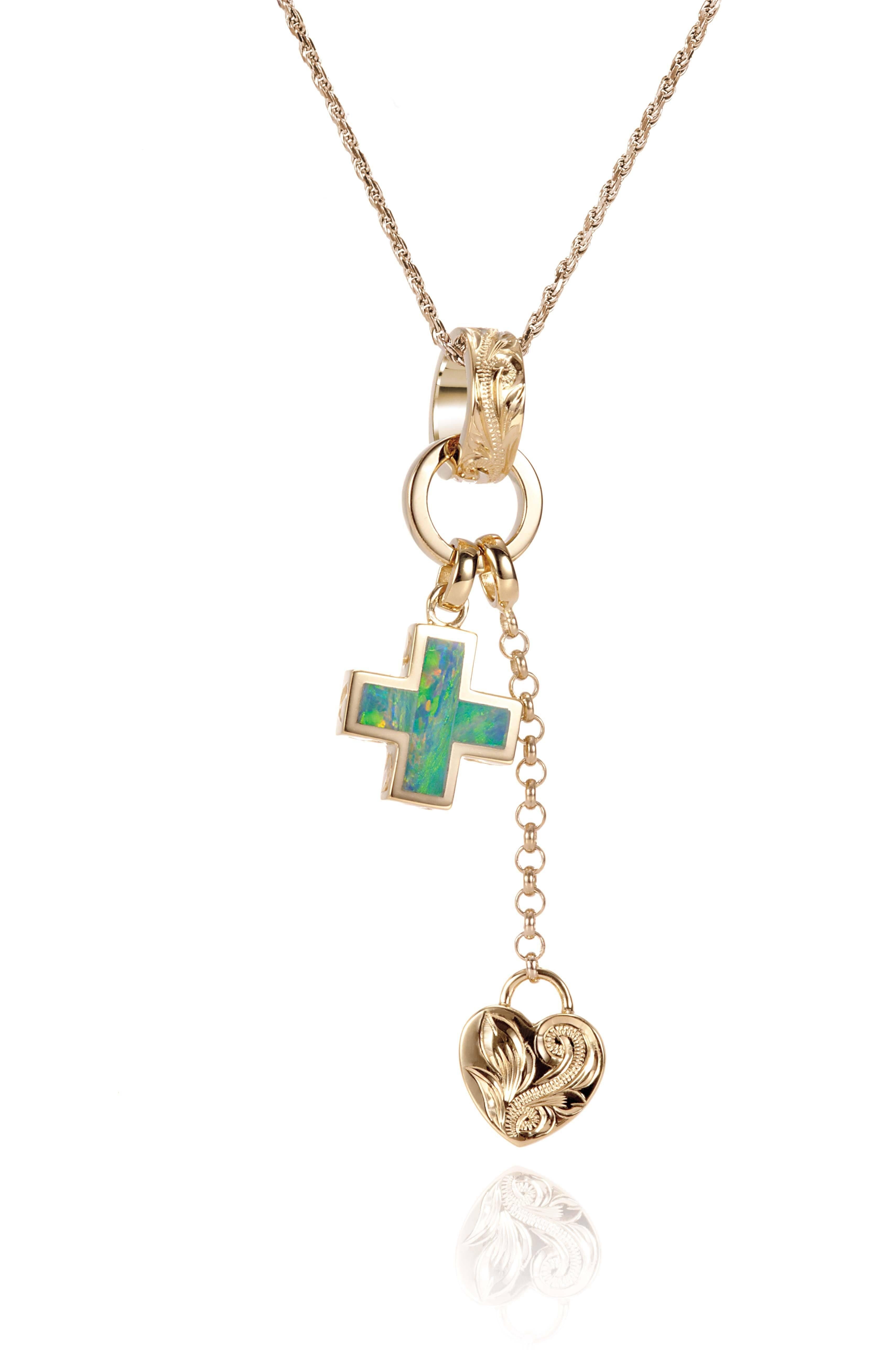 The picture shows a 14K yellow gold opal cross and heart charm pendant with hand engravings.