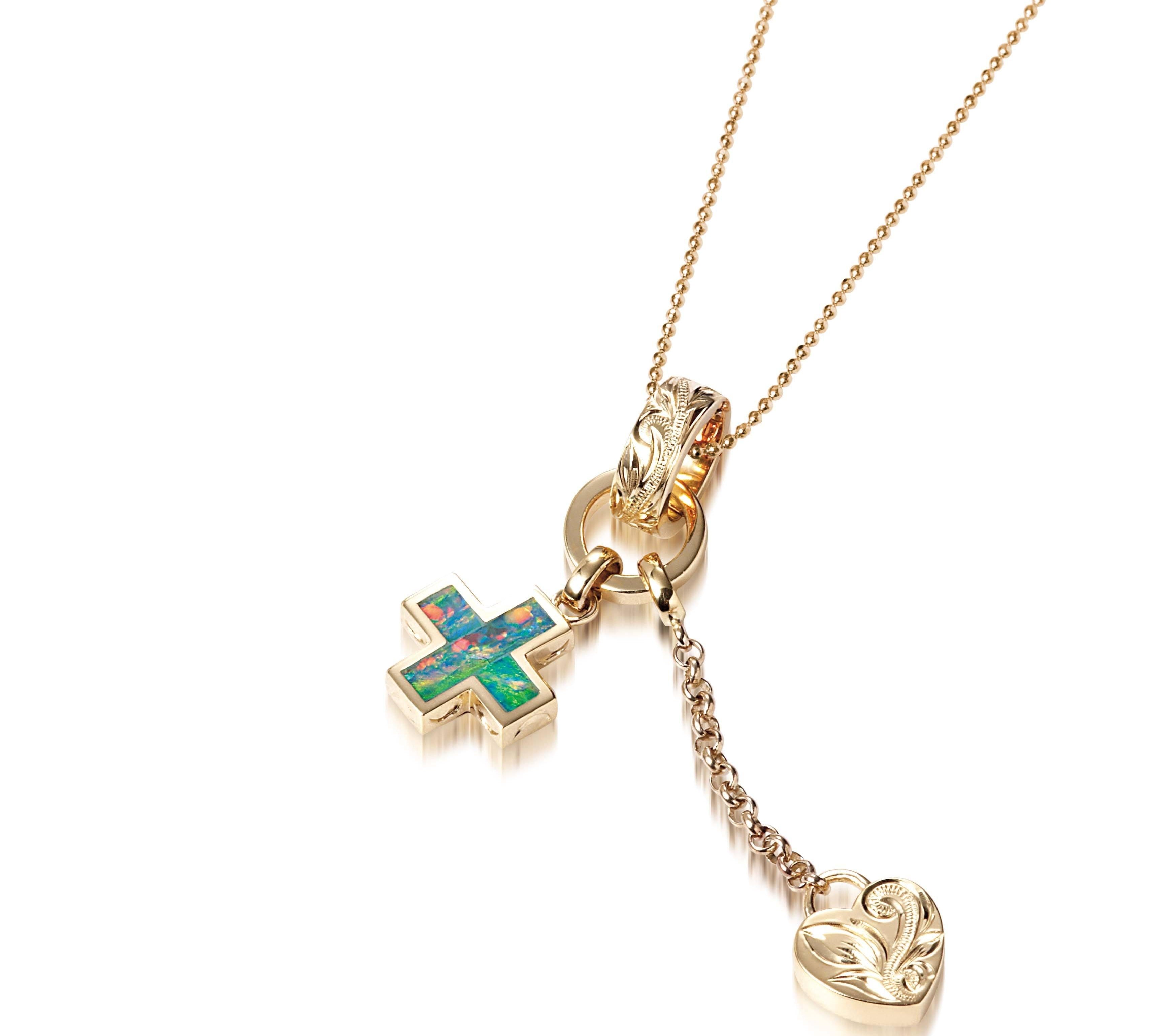 The picture shows a 14K yellow gold opal cross and heart charm pendant with hand engravings.