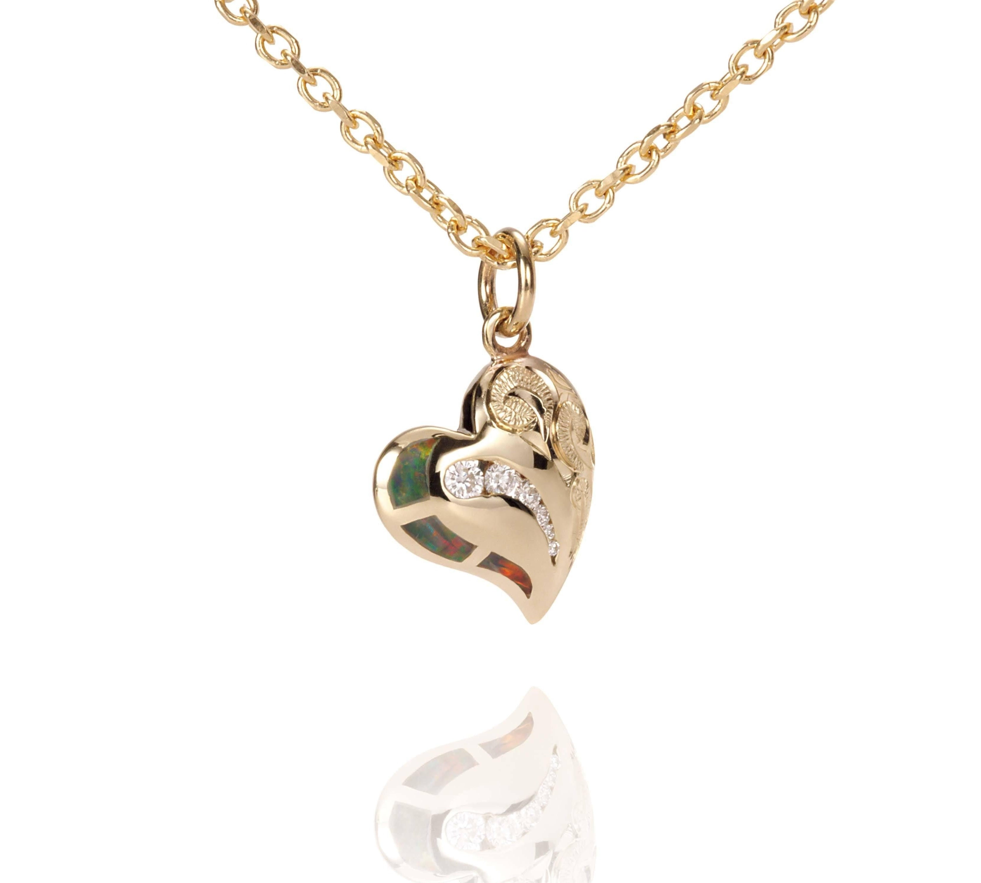 The picture shows a 14K yellow gold opal heart pendant with hand engravings.