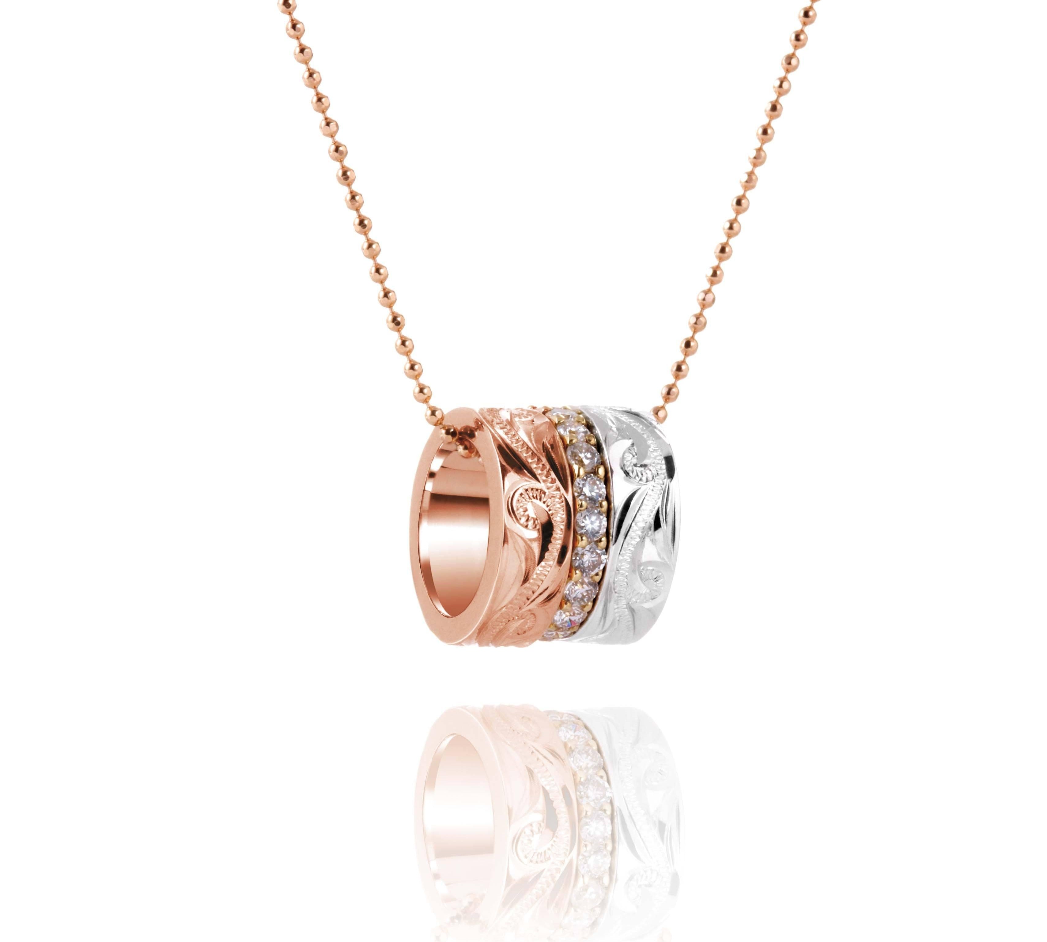 The picture shows a 14K rose, yellow, and white gold barrel pendant with diamonds.