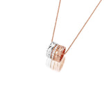 The picture shows a 14K rose, yellow, and white gold barrel pendant with diamonds.