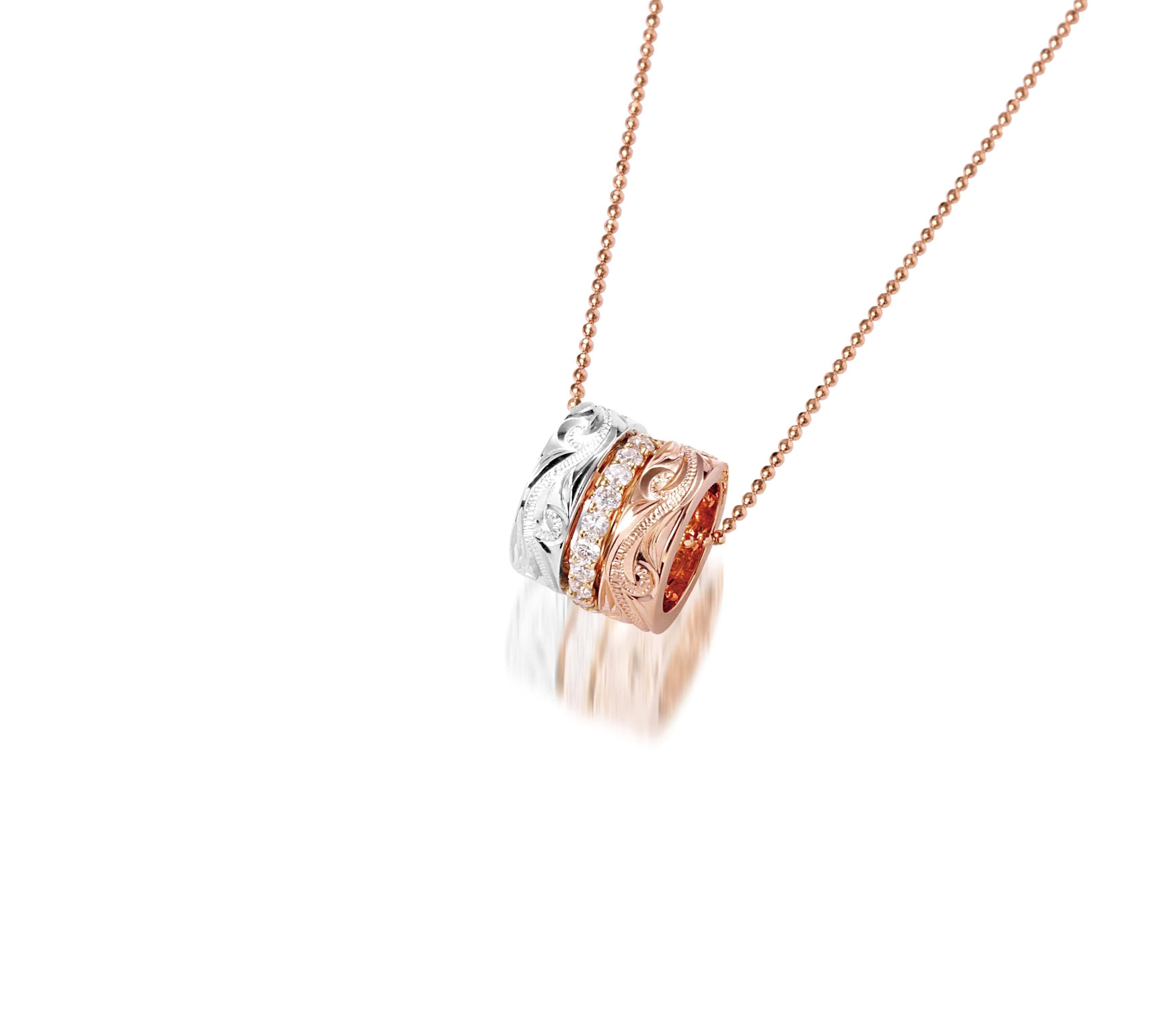 The picture shows a 14K rose, yellow, and white gold barrel pendant with diamonds.