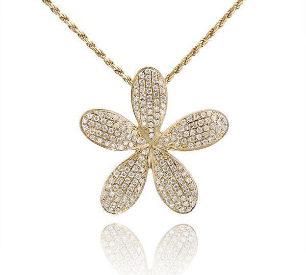 In this photo there is a large yellow gold plumeria pendant with diamonds. 