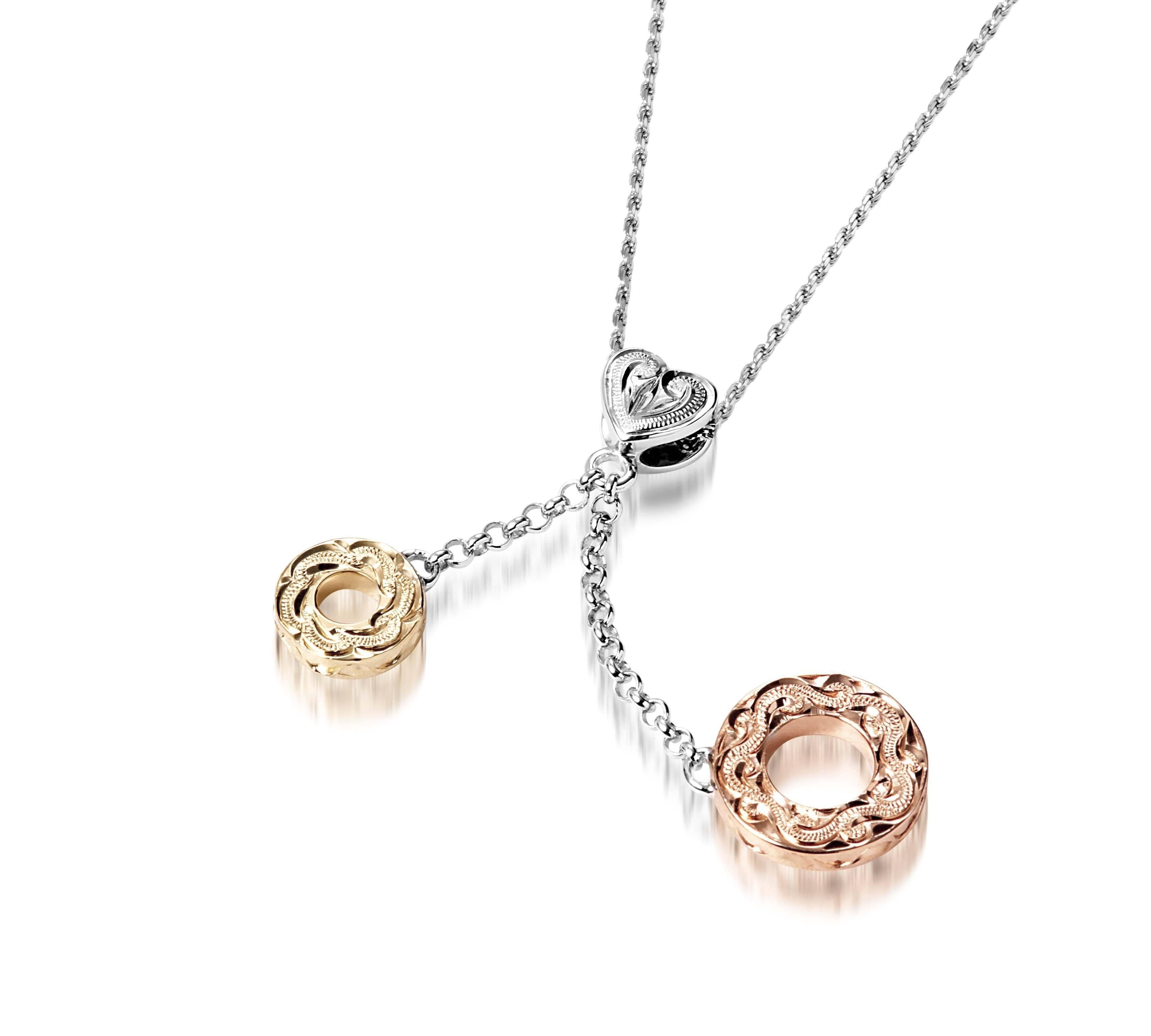 The picture shows a 14K rose and yellow gold two circles and one heart charm pendant with hand engravings.