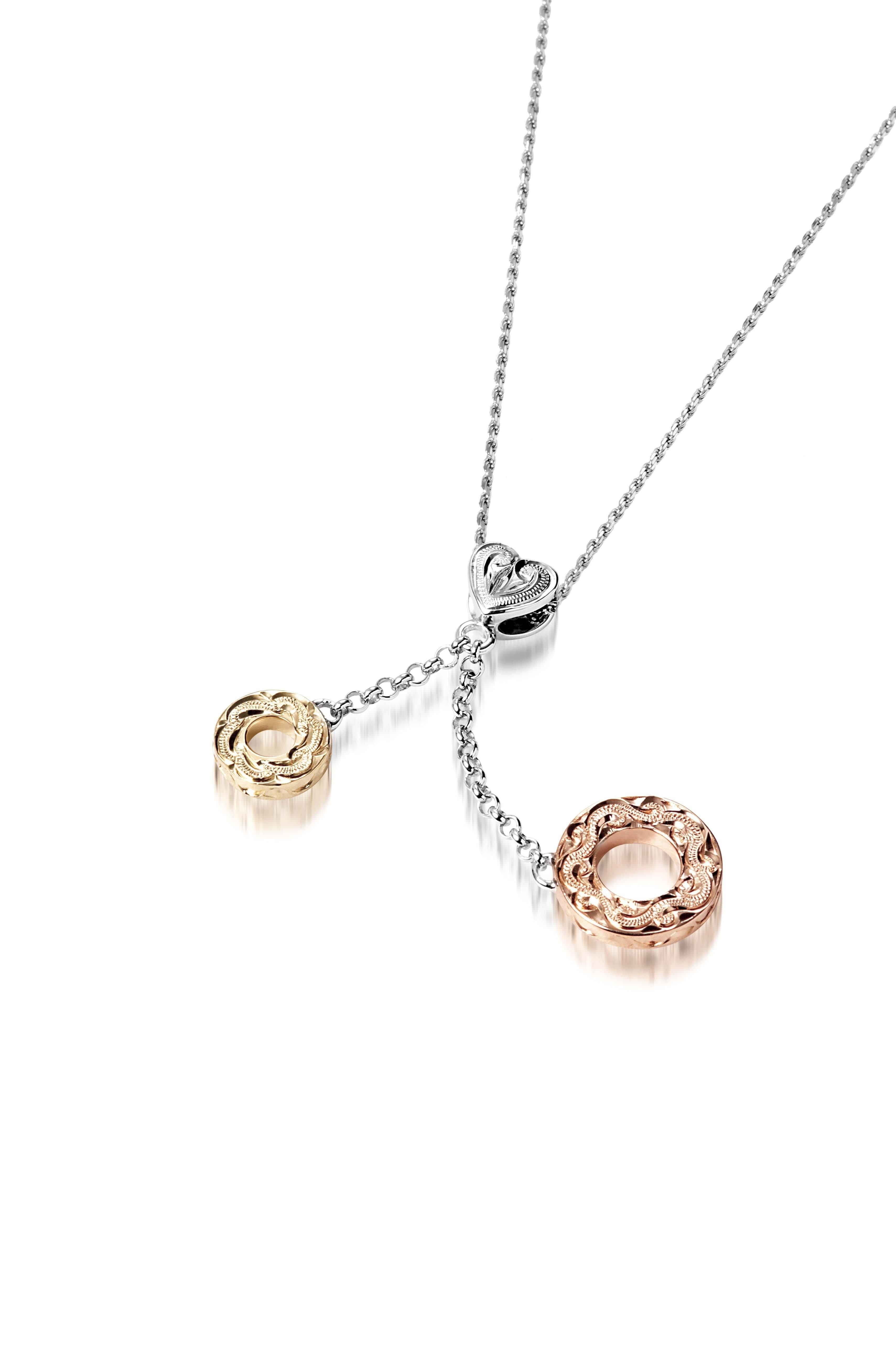 The picture shows a 14K rose and yellow gold two circles and one heart charm pendant with hand engravings.