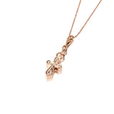 The picture shows a 14K rose gold pointed cross charm with hand-engraved detailing.