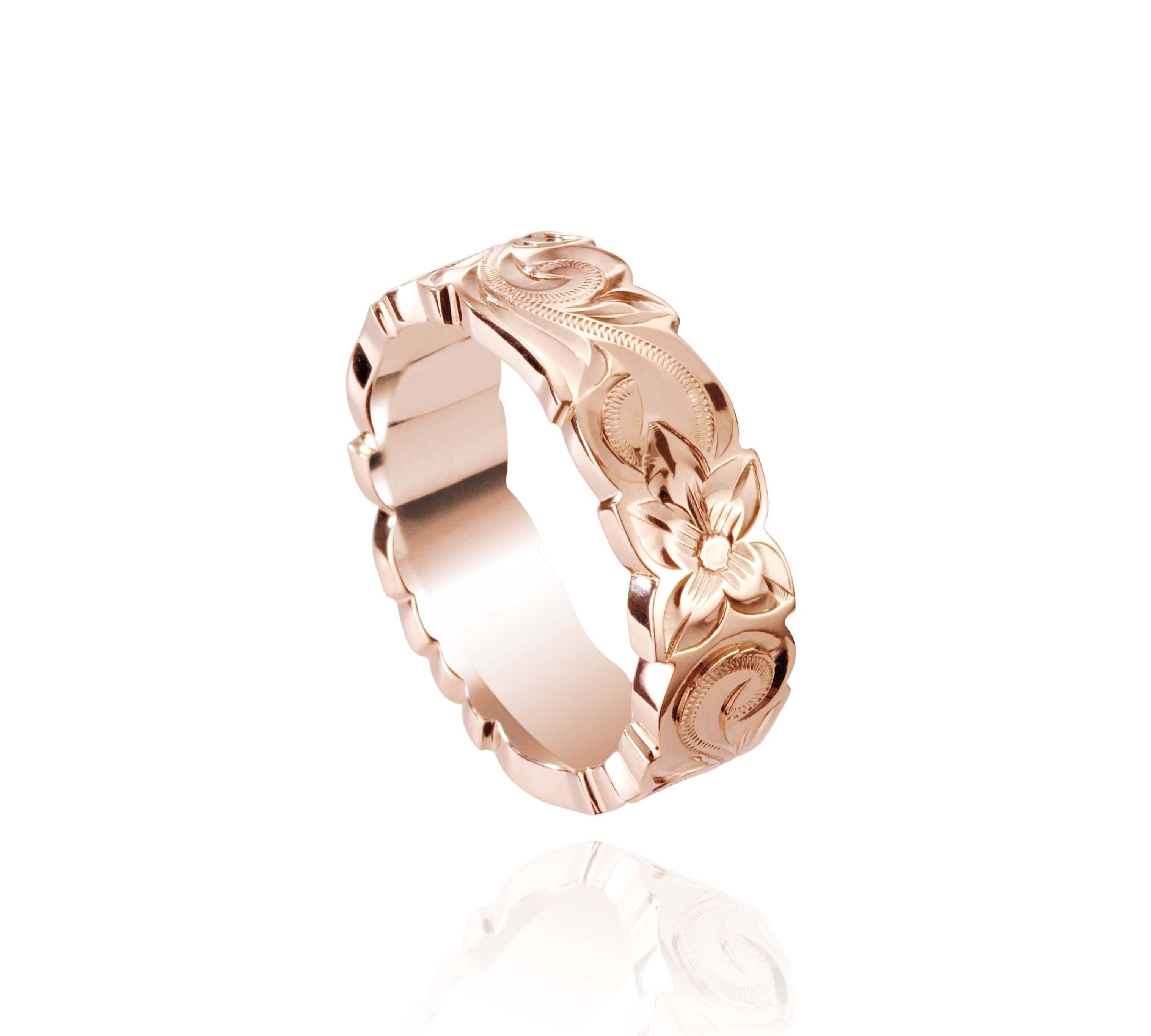 In this picture there is a rose gold cut out ring with hand engravings including flowers and scrolls.