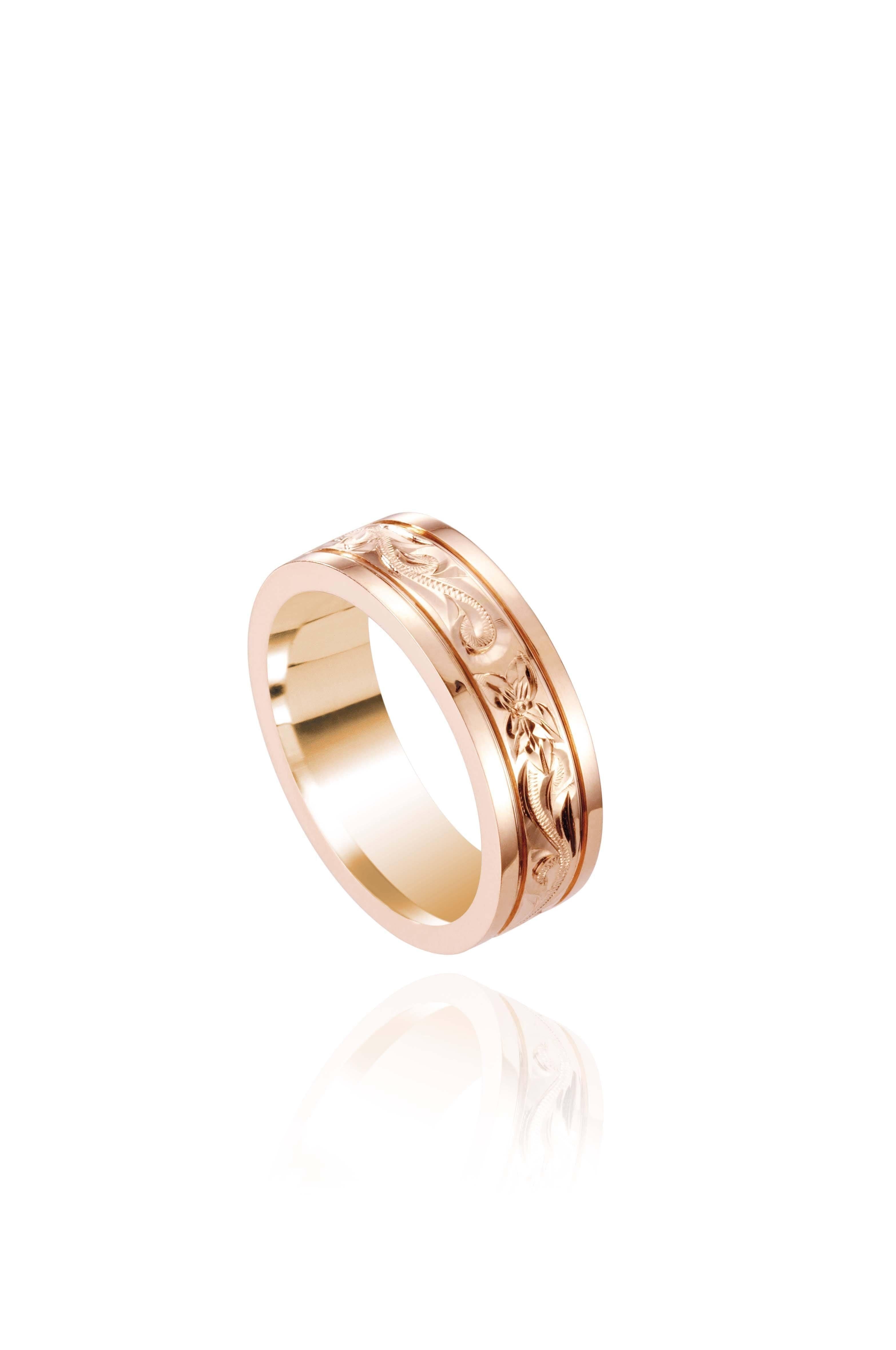 In this photo there is a rose gold ring with flower and scroll hand-engravings.
