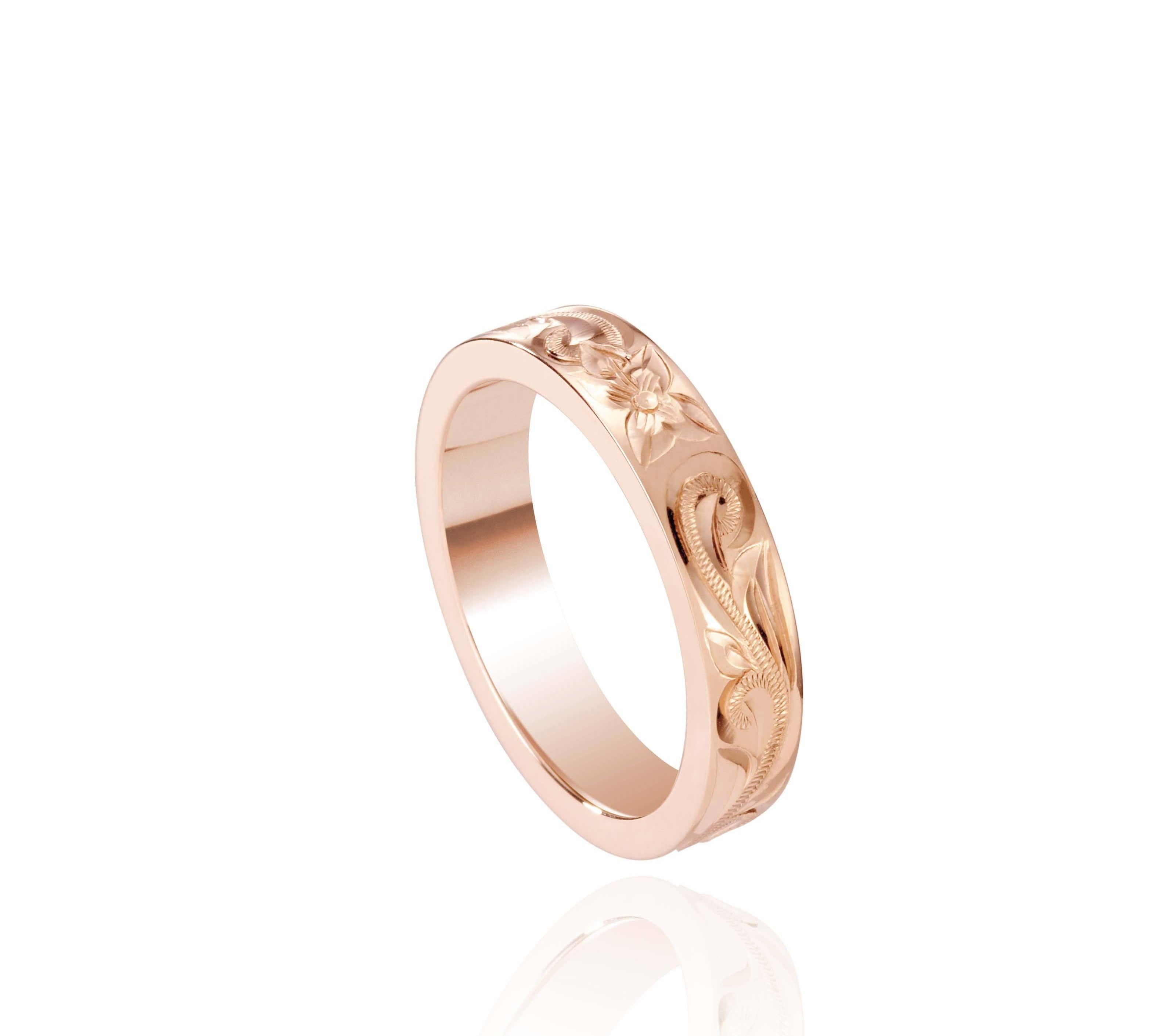 In this photo there is a rose gold ring with flower and scroll hand engravings.
