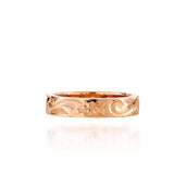 In this photo there is a rose gold ring with flower and scroll hand engravings.