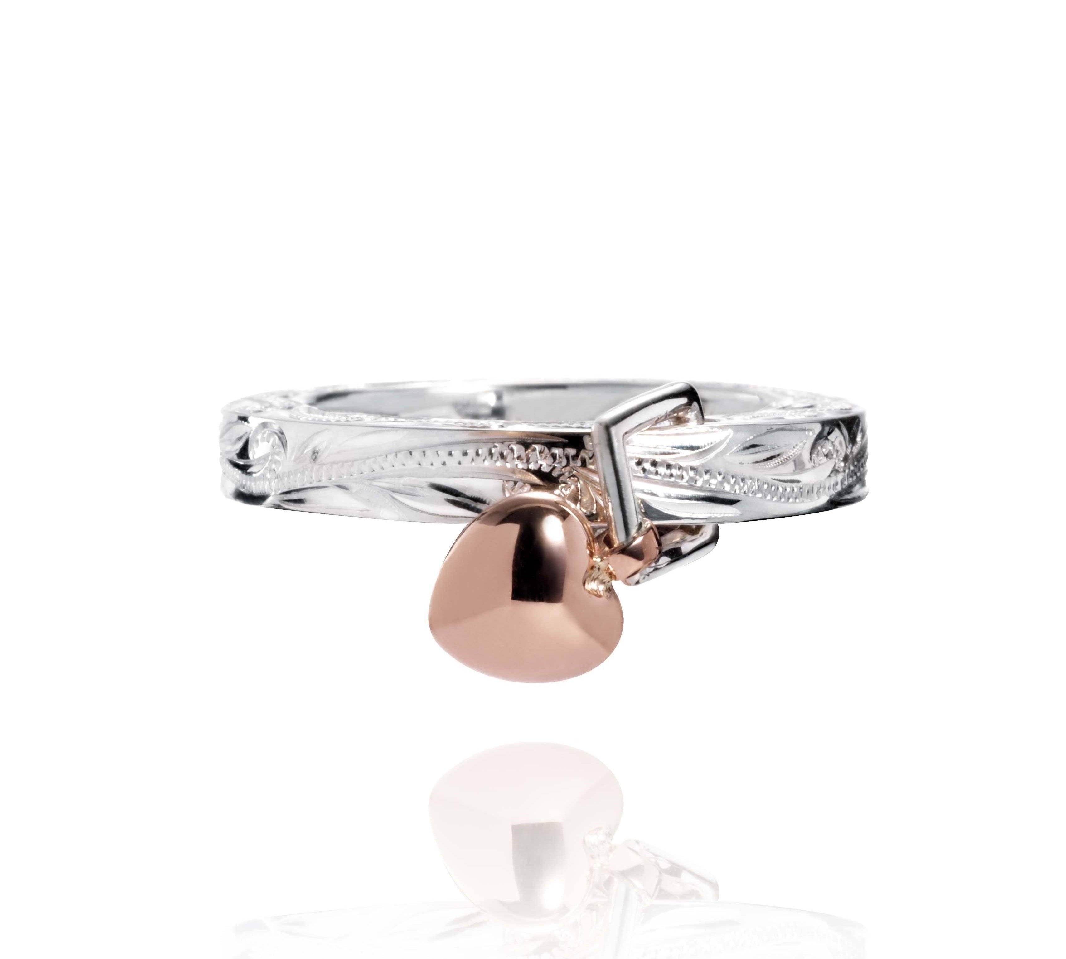 The picture shows a 14K rose gold and 925 sterling silver heart ring with hand engravings.