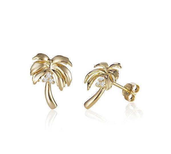 In this photo there is a large pair of 14k yellow gold palm tree stud earrings with diamond coconuts.