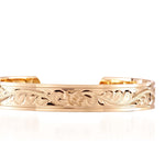 The picture shows a 14K yellow gold royal bangle with sea turtle engravings.