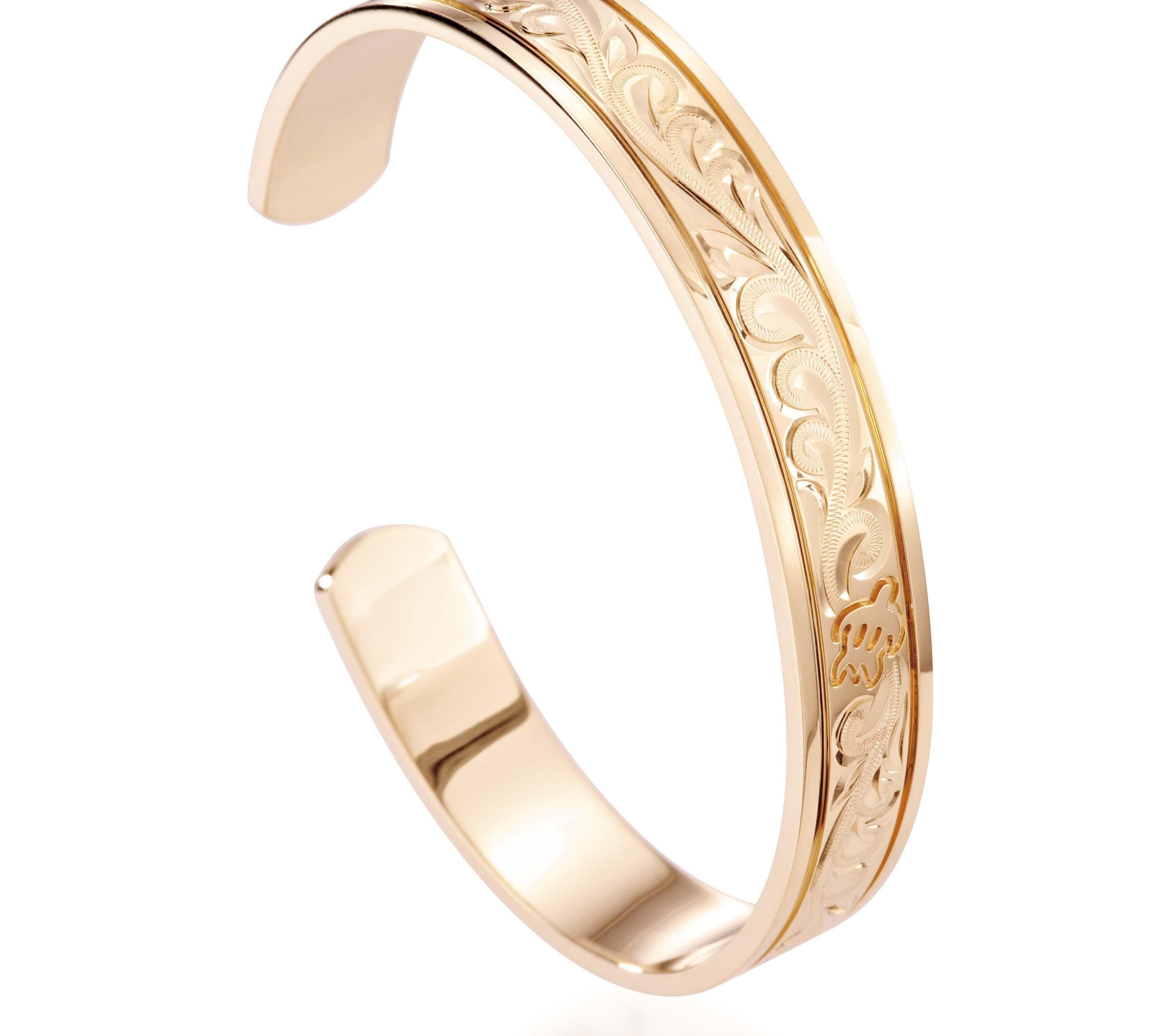 The picture shows a 14K yellow gold royal bangle with sea turtle engravings.