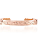 The picture shows a 14K rose gold royal bangle with plumeria engravings.