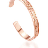 The picture shows a 14K rose gold royal bangle with plumeria engravings.