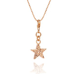 The picture shows a 14K rose gold star charm with paisley hand engravings.