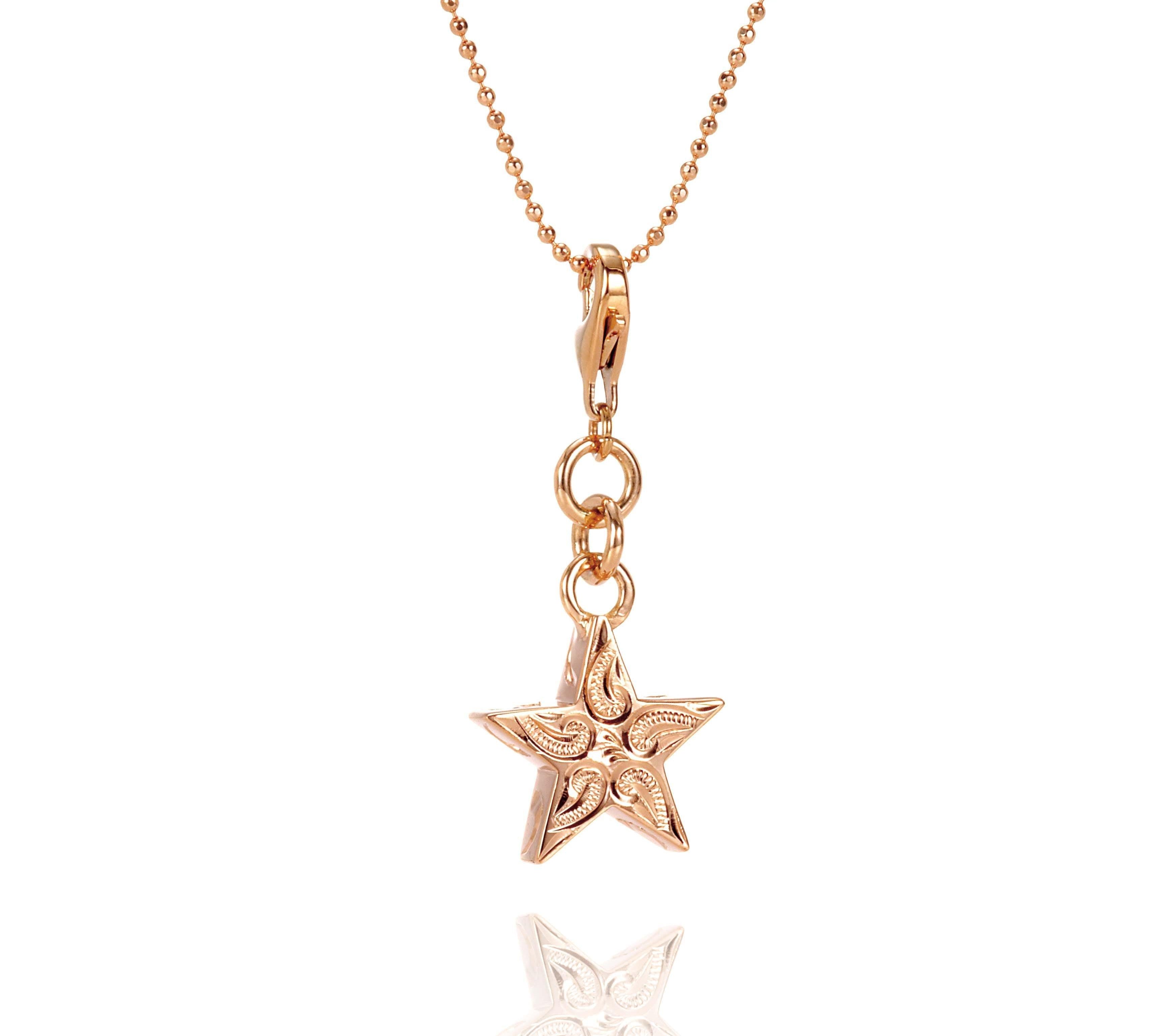 The picture shows a 14K rose gold star charm with paisley hand engravings.