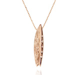 In this photo there is a rose gold surfboard pendant with diamonds and hand engravings.