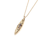 In this photo there is a yellow gold surfboard pendant with an opal cross and hand engravings.
