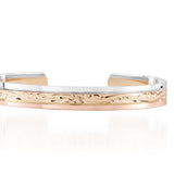 The picture shows a 14K white, yellow, and rose gold tri-color bangle with plumeria engraving.