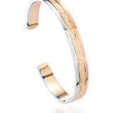 The picture shows a 14K white, yellow, and rose gold tri-color bangle with plumeria engraving.