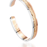 The picture shows a 14K white, yellow, and rose gold tri-color bangle with scroll engraving.